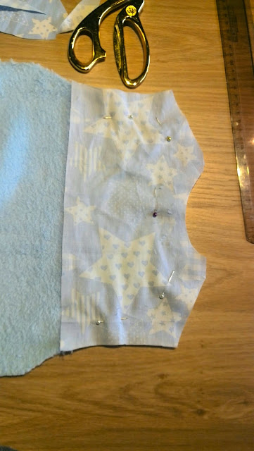 Beleg van bijpassende sterren-stof opgespeld voor de halsopening van het slaapzakje