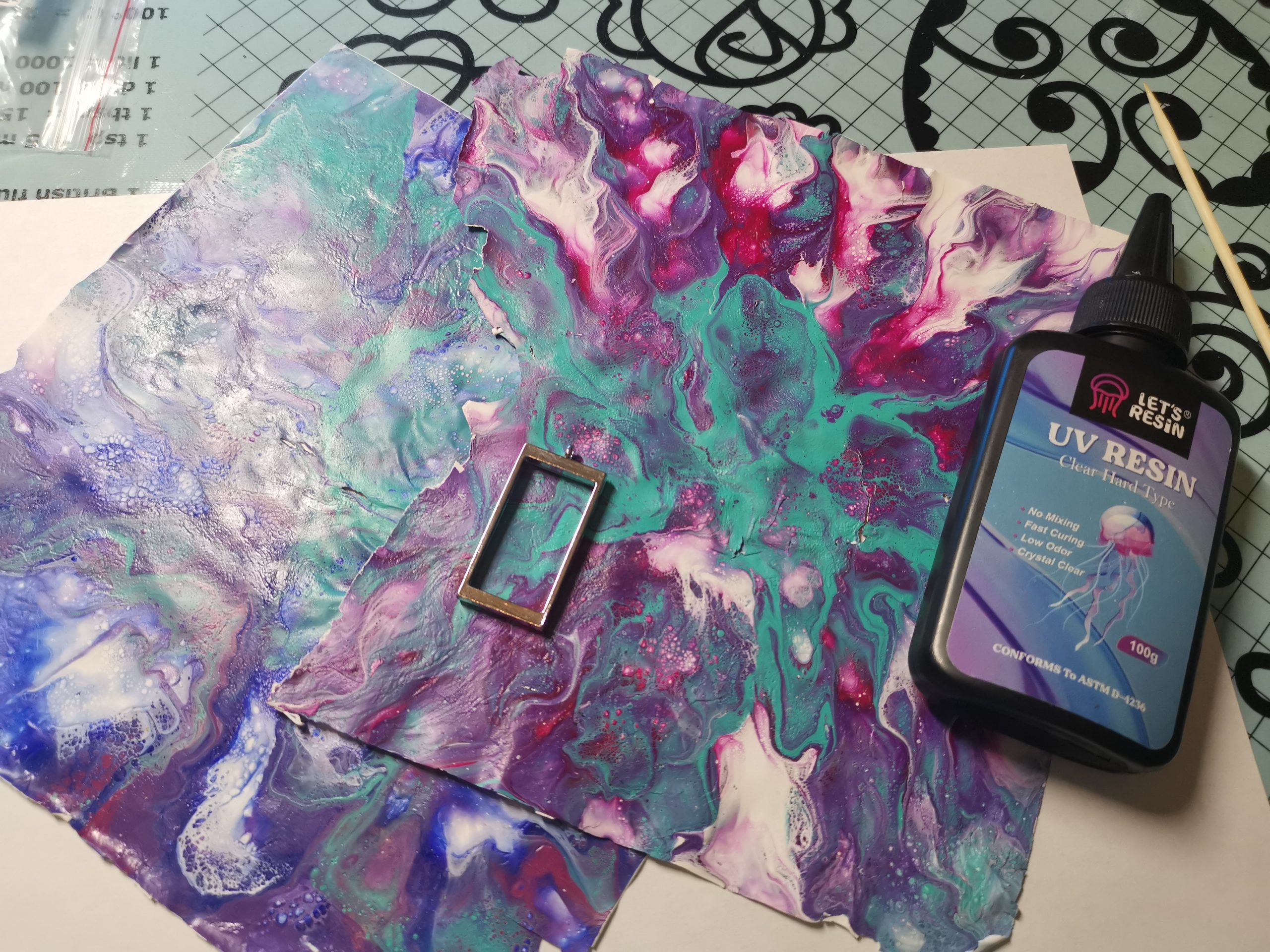 Fluid-art sheet with pendant frame and UV resin