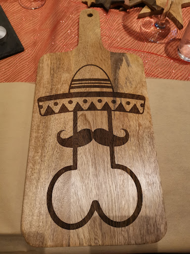 Houten snijplank met humoristische gravure en sombrero-motief.