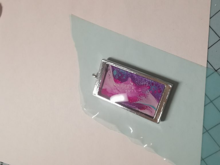 Fluid-art insert in pendant frame with UV resin over it