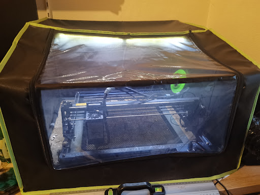 Detail van de rookafvoer met flexibele slang en afzuigpoort van de laserbehuizing.