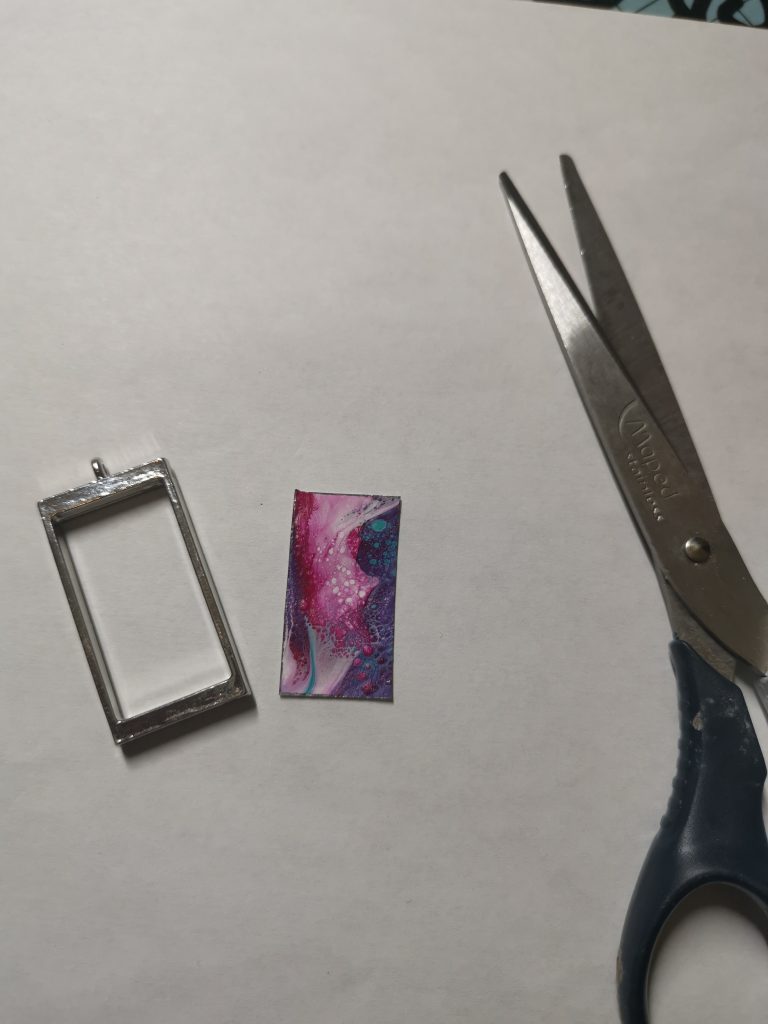 Uitgesneden inlegstuk naast hanger en schaar