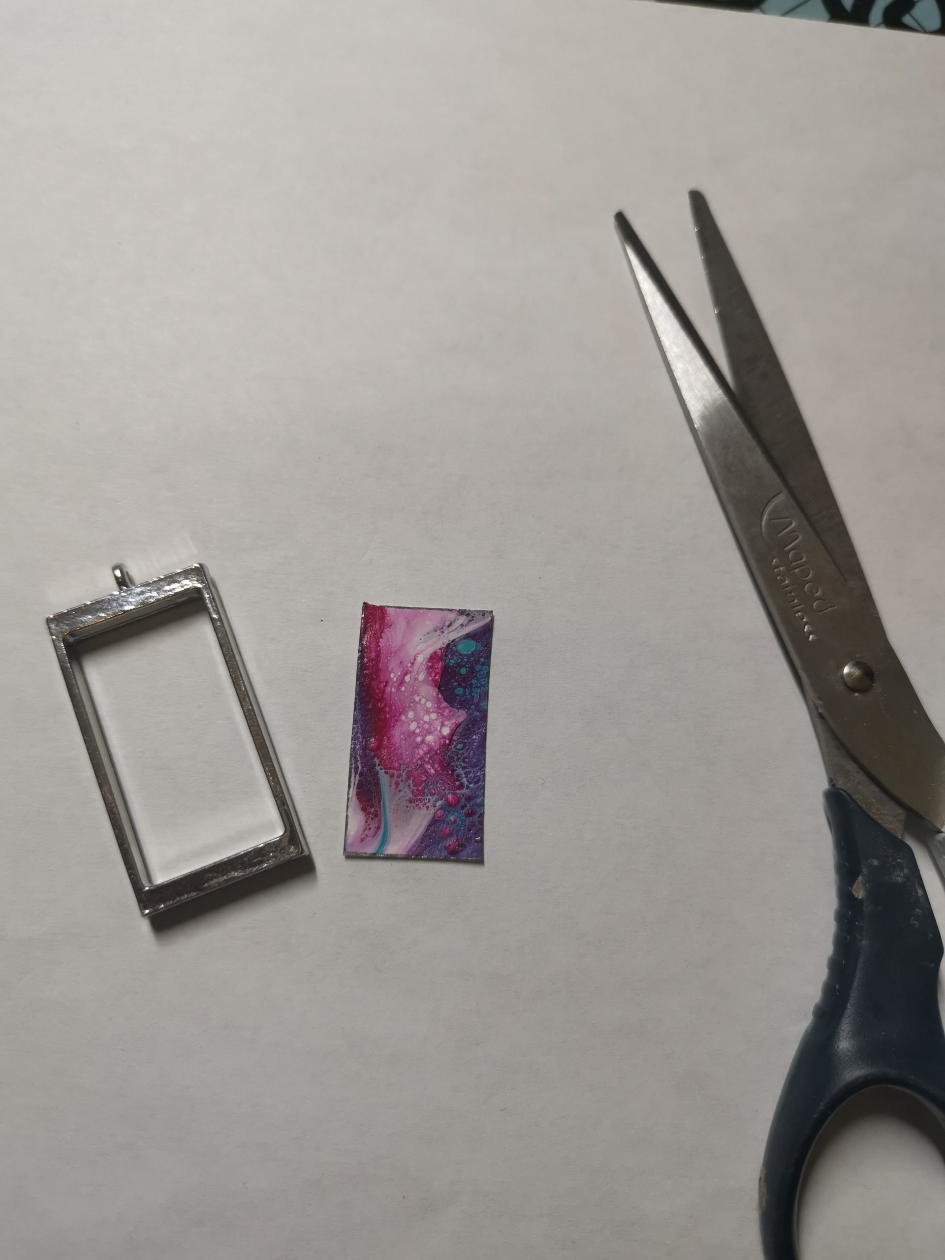 Cut fluid-art insert next to pendant frame