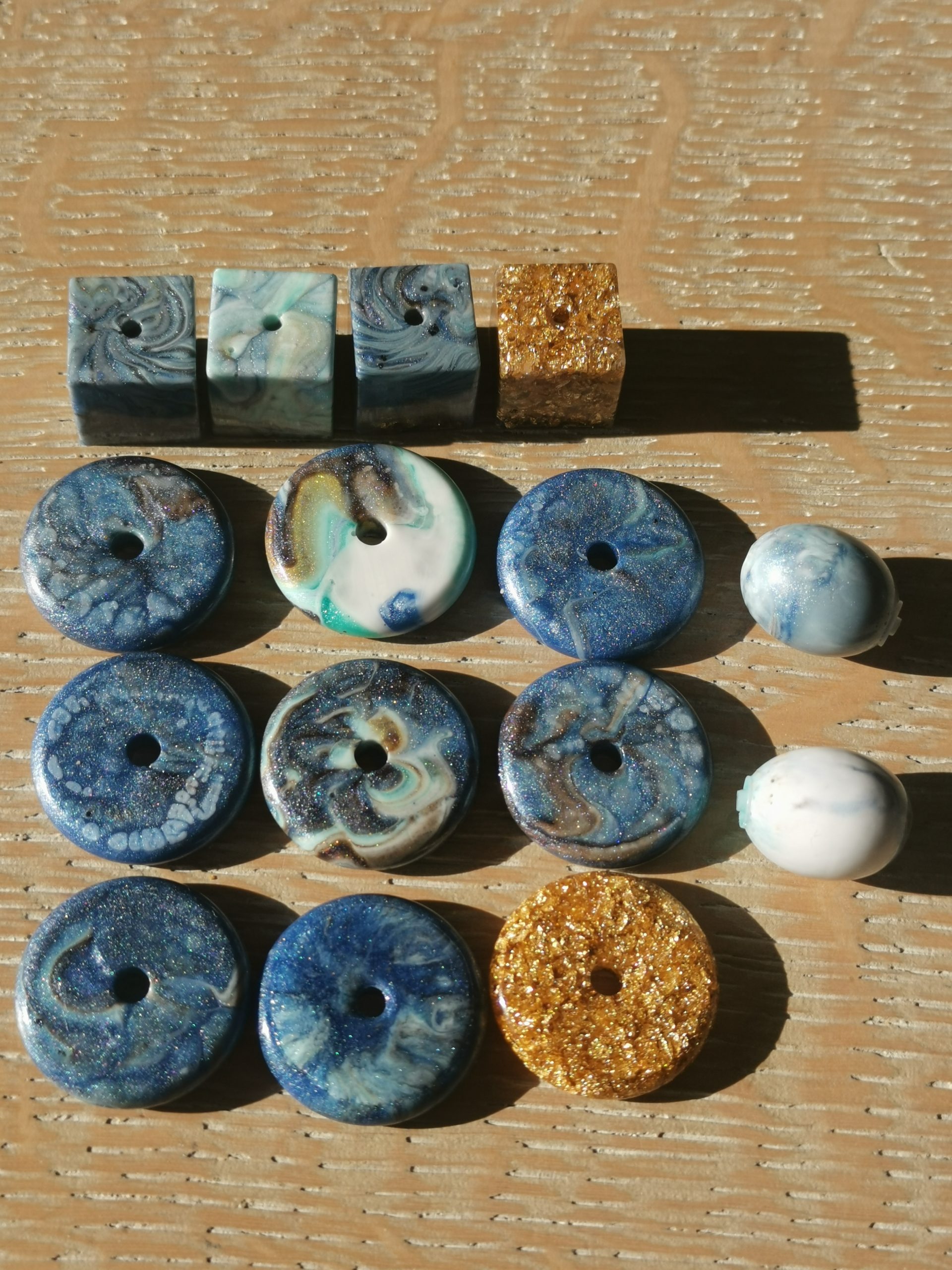 Uitgeharde resin parels en kubussen van restjes: blauw, teal, goud