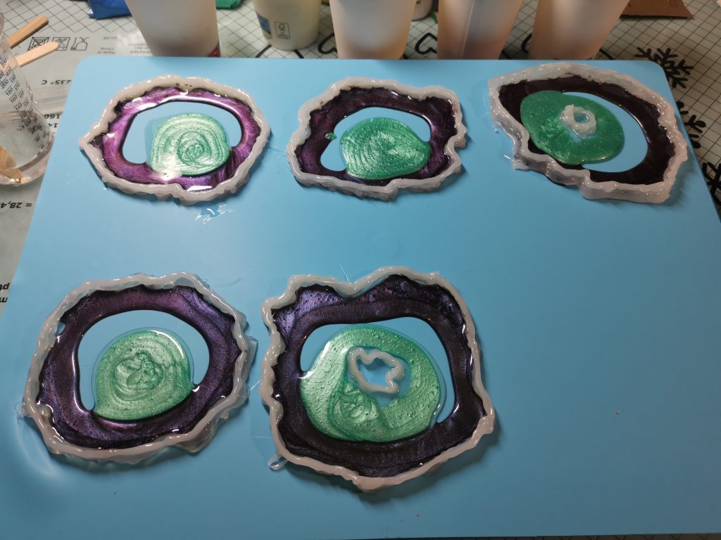 Drie resin geode onderzetters in warme kleurtinten