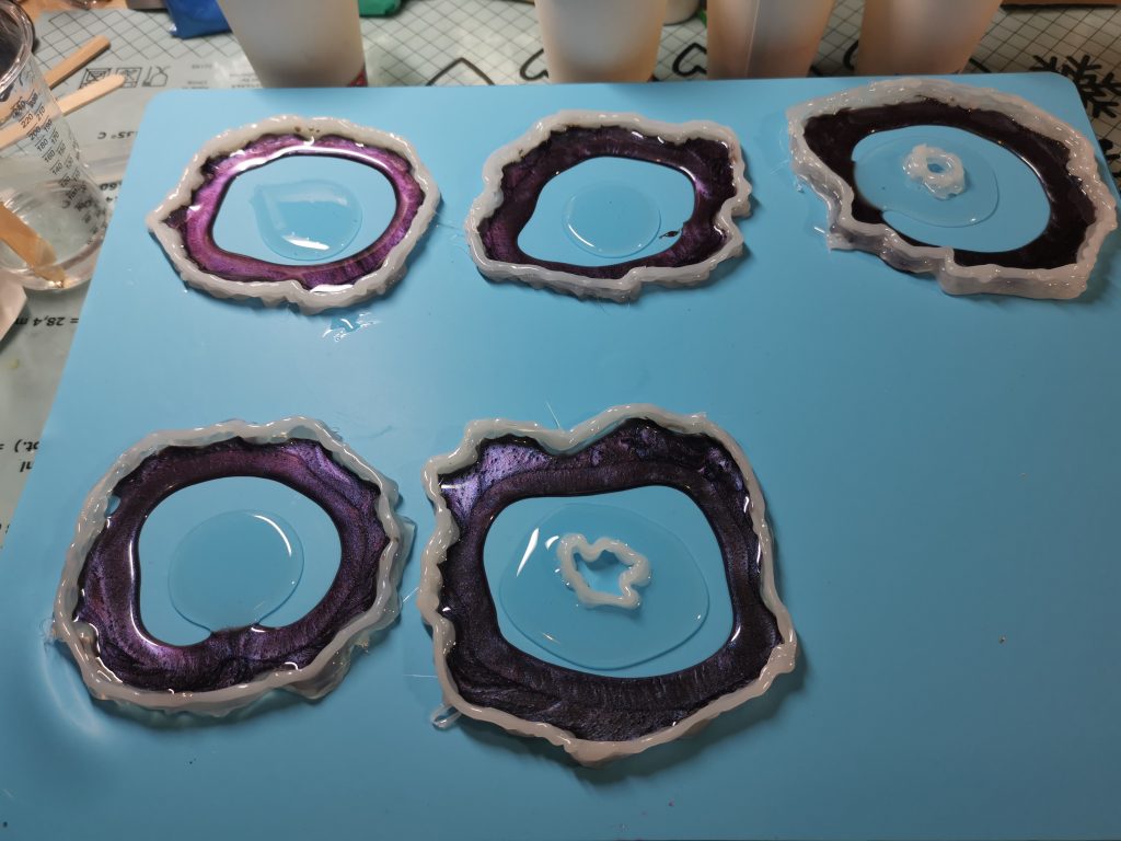 Drie resin geode onderzetters op werktafel