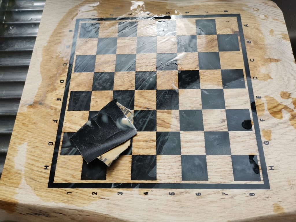 Eiken schaakbord in wording met zwarte epoxy op de schaakruiten en schuurpapier