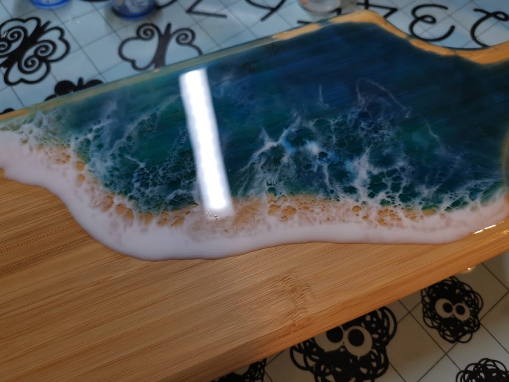 Rechthoekige bamboe tapasplank met afgewerkt oceaan epoxy motief in blauw turquoise en wit