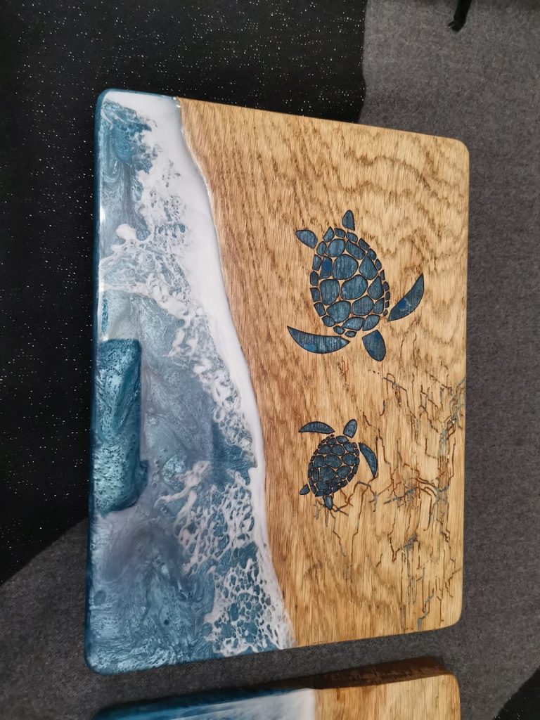 Eiken tapasplank met blauw oceaan epoxy en twee lasergeëtste zeeschildpadden op het hout