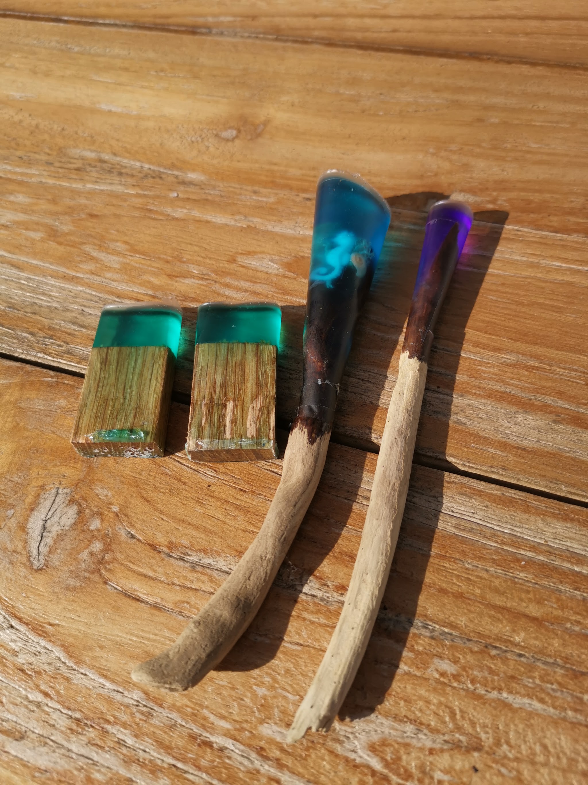 Eikblokjes en drijfhout hairpins na de eerste uitharding op een houten tafel: de bovenkant-uiteinden zijn hard en gekleurd, de punten zijn nog volledig kaal hout