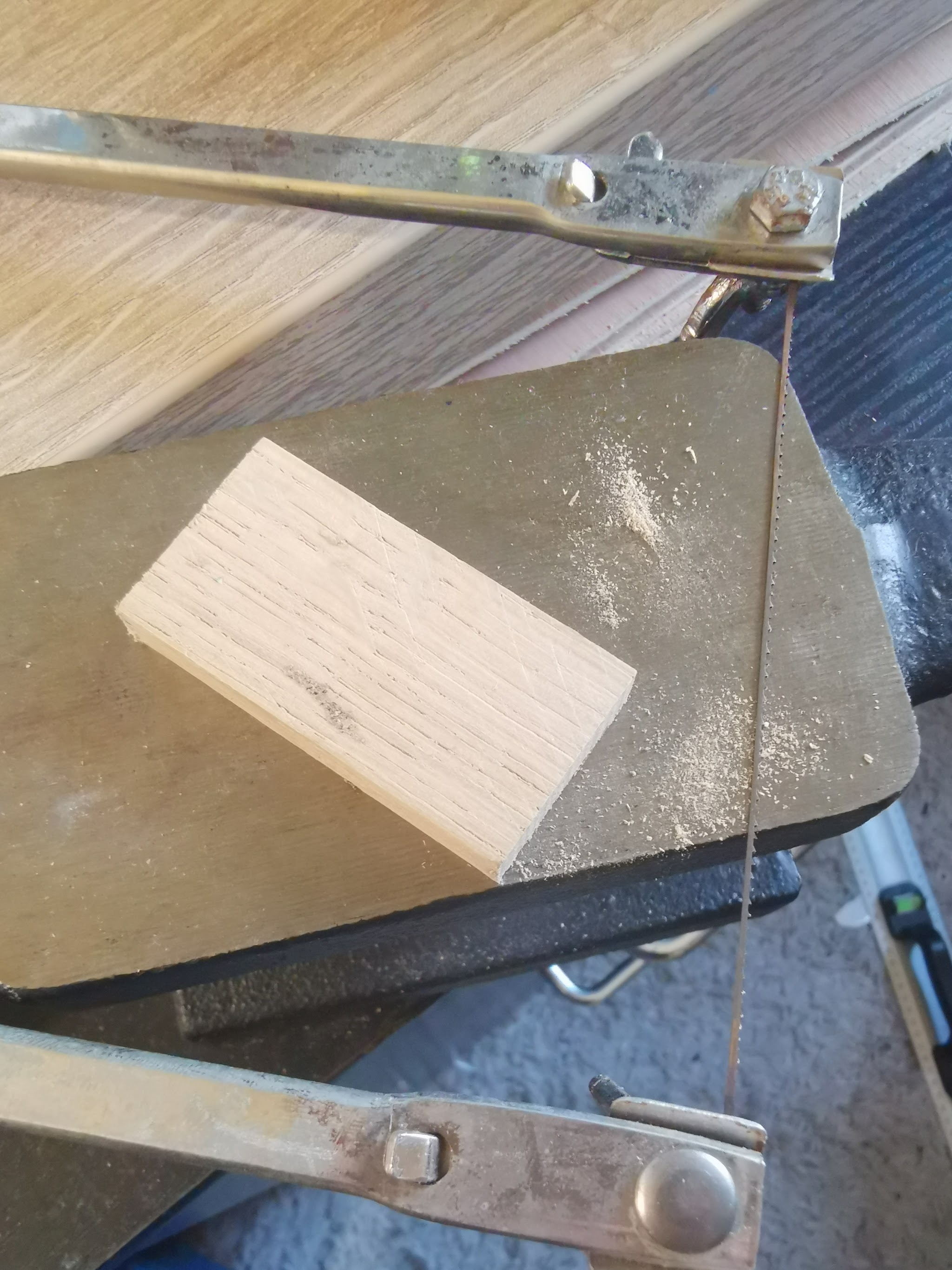 Eikblokje vastgeklemd in een bankschroef, wordt gedeeltelijk doorgezaagd voor een ruwe, natuurlijke breukrand