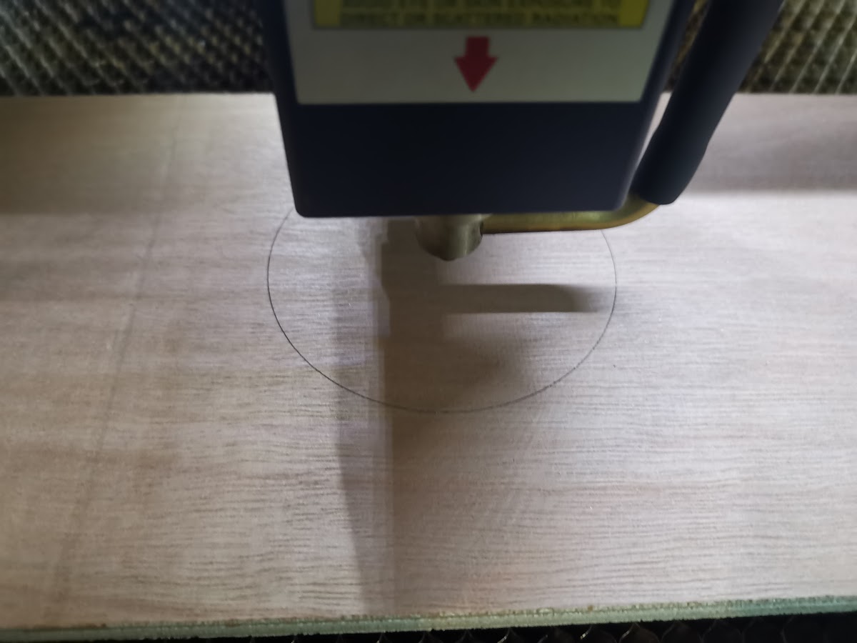 Laserhoofd brandt een cirkelvormige placeholder in het multiplex — de mal voor de coaster positionering