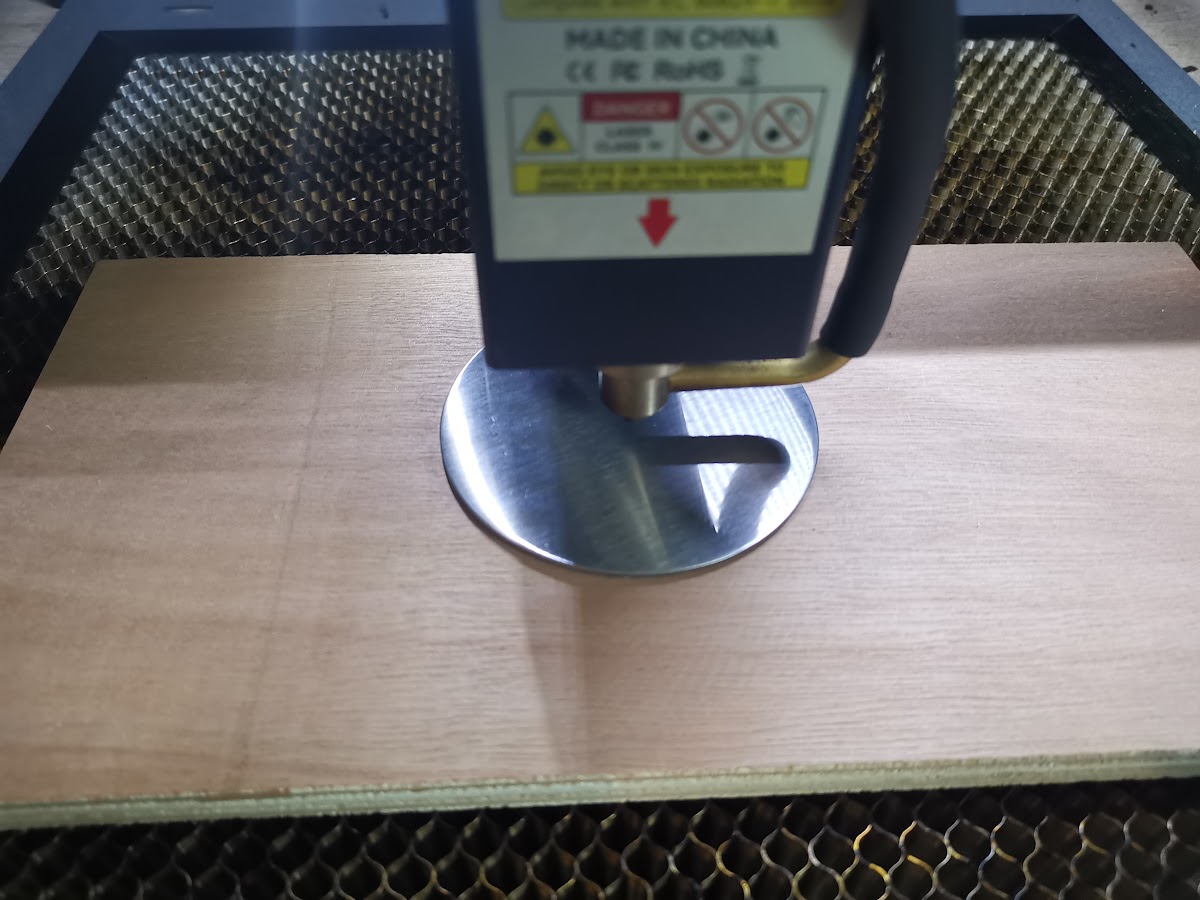 Close-up van laserhoofd boven coaster die perfect in de ingegraveerde cirkelmal op het hout past