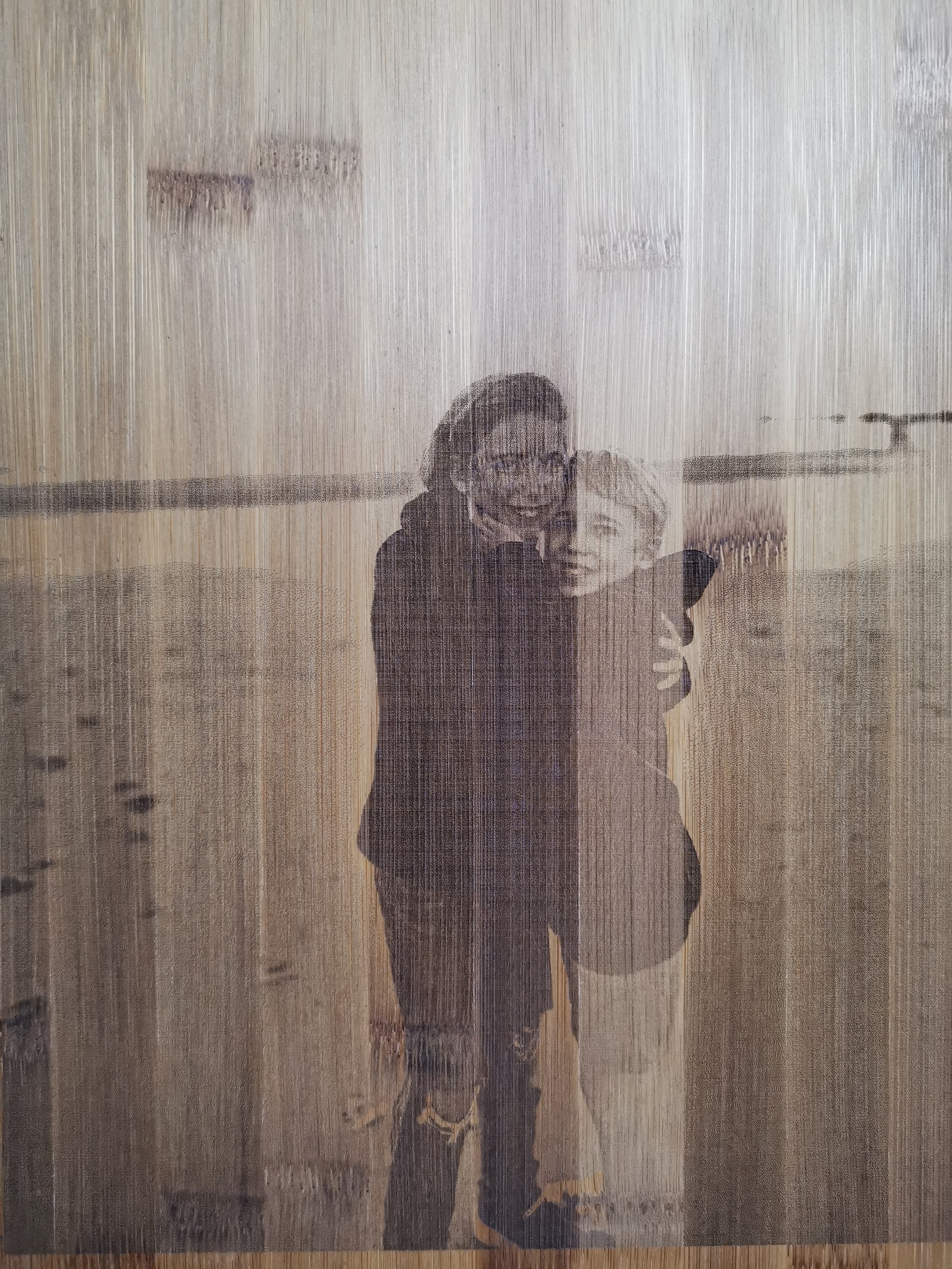 Bamboe snijplank met portretfoto van koppel gegraveerd, gefotografeerd vanuit schuine hoek