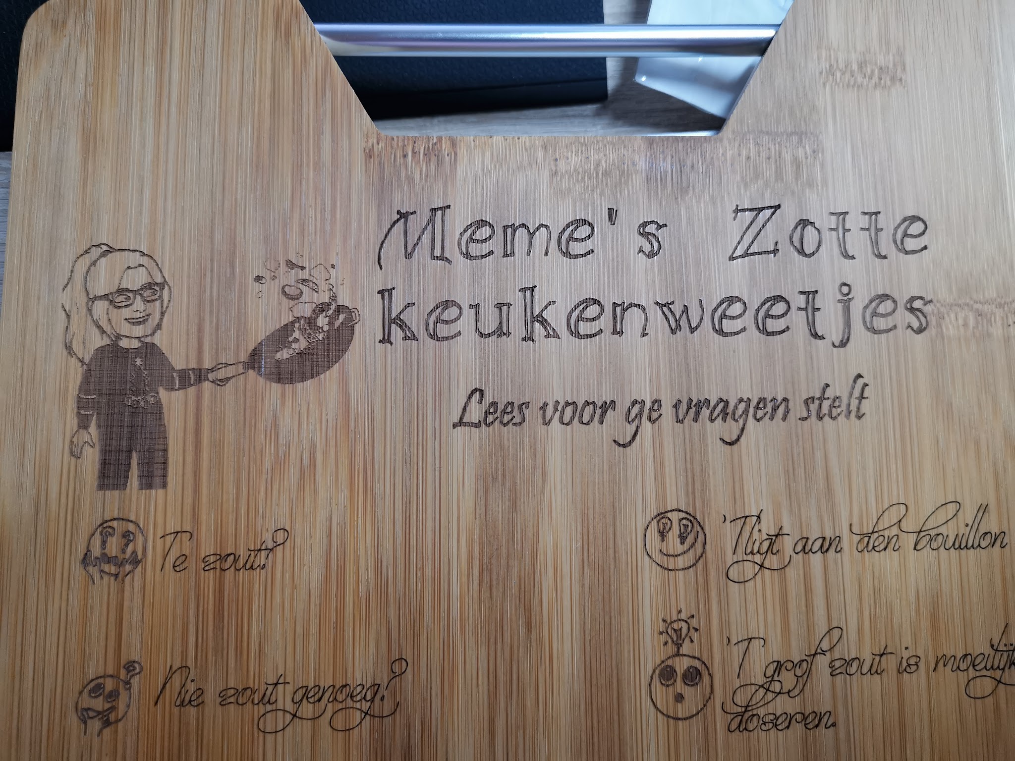 Bamboeplank met gegraveerde tekst Meme's Zotte Keukenweetjes en illustratie van figuur met lepel