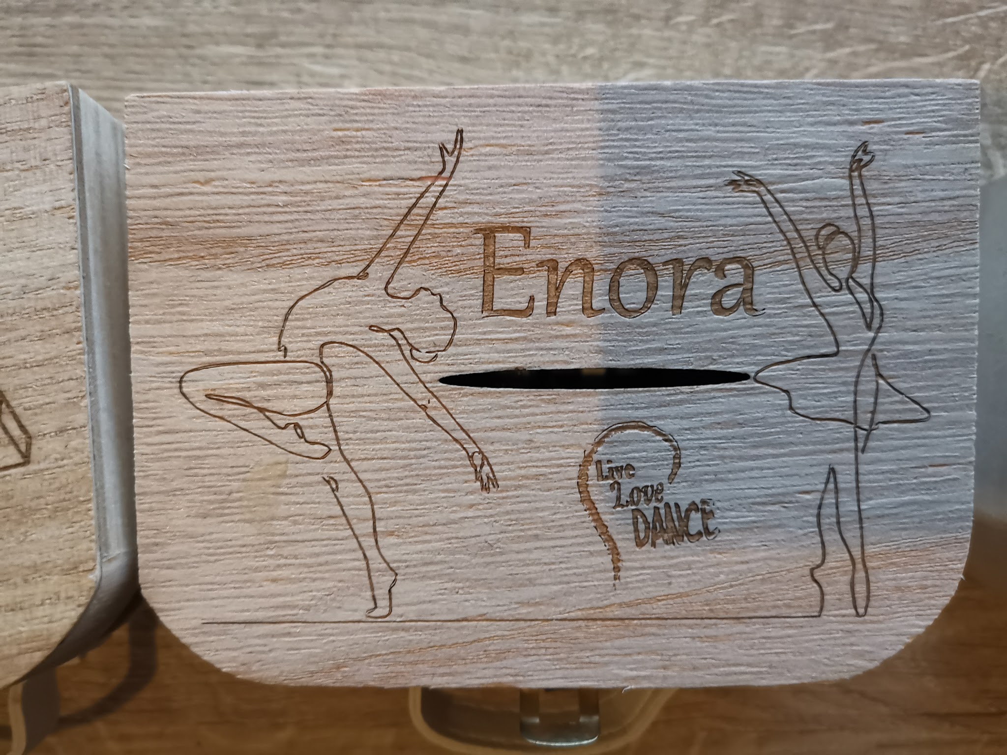 Rond houten doosje met naam Enora in sierlijk schrift en dansende figuurtjes