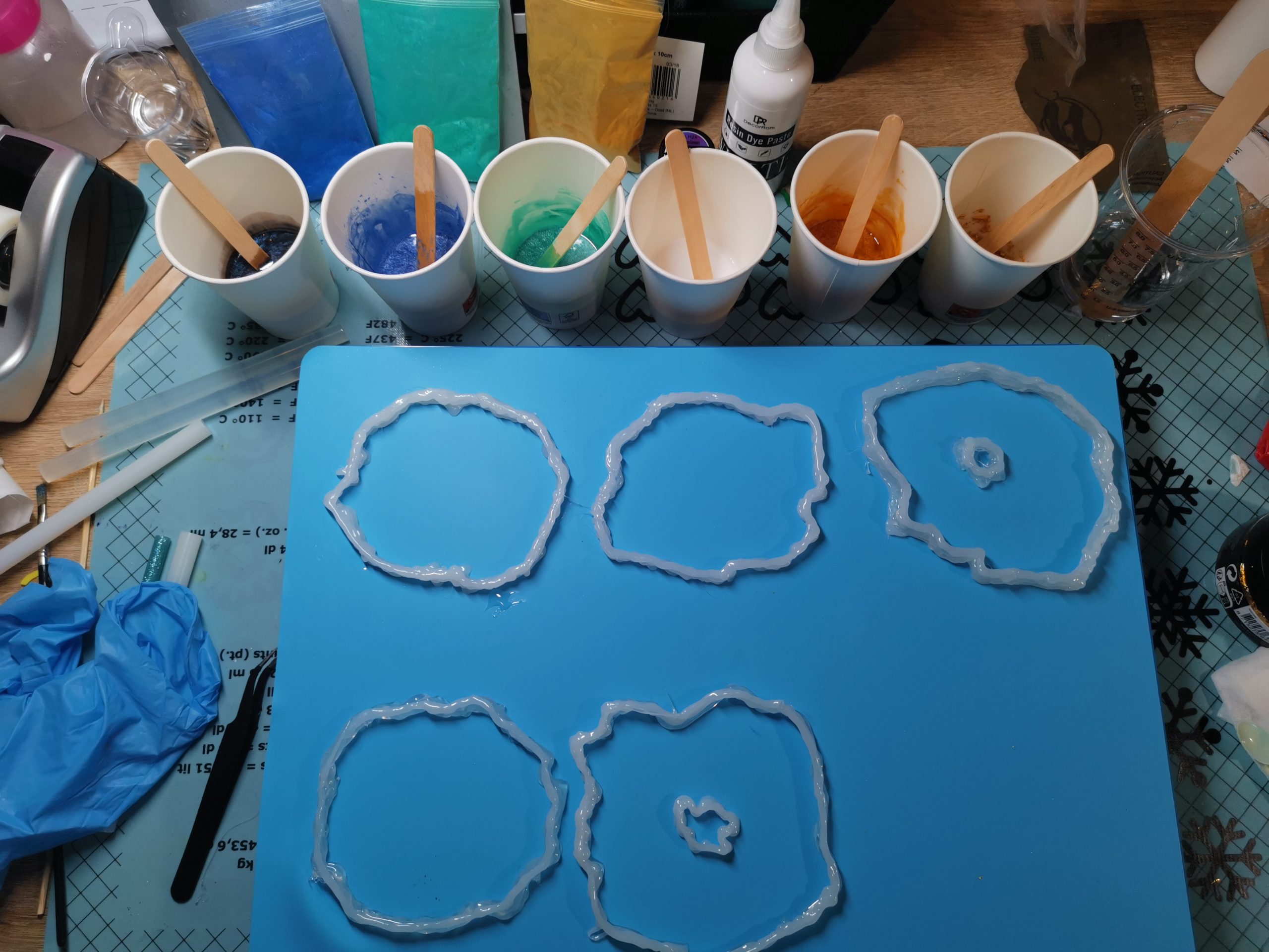 Werkopstelling klaar: vijf freeform mallen, zes mengbekers met gekleurde resin, handschoenen en gereedschap