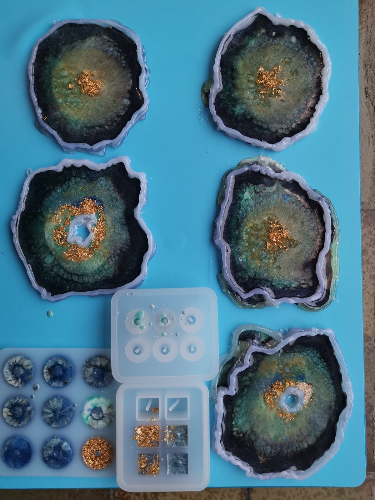 Overview of the four epoxy coasters and the silicone mold with resin beads in progress