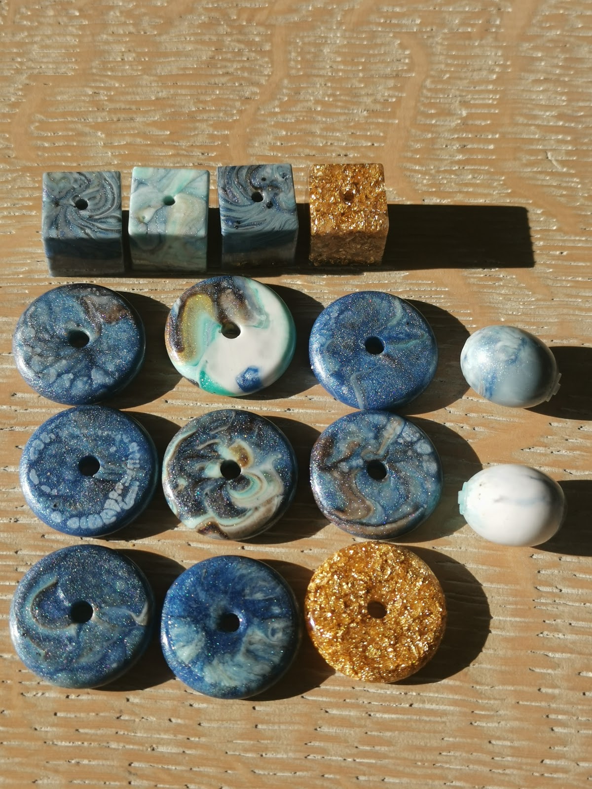 Full collection of handmade resin beads: donut discs, cubes and round balls in blue, gold and turquoise