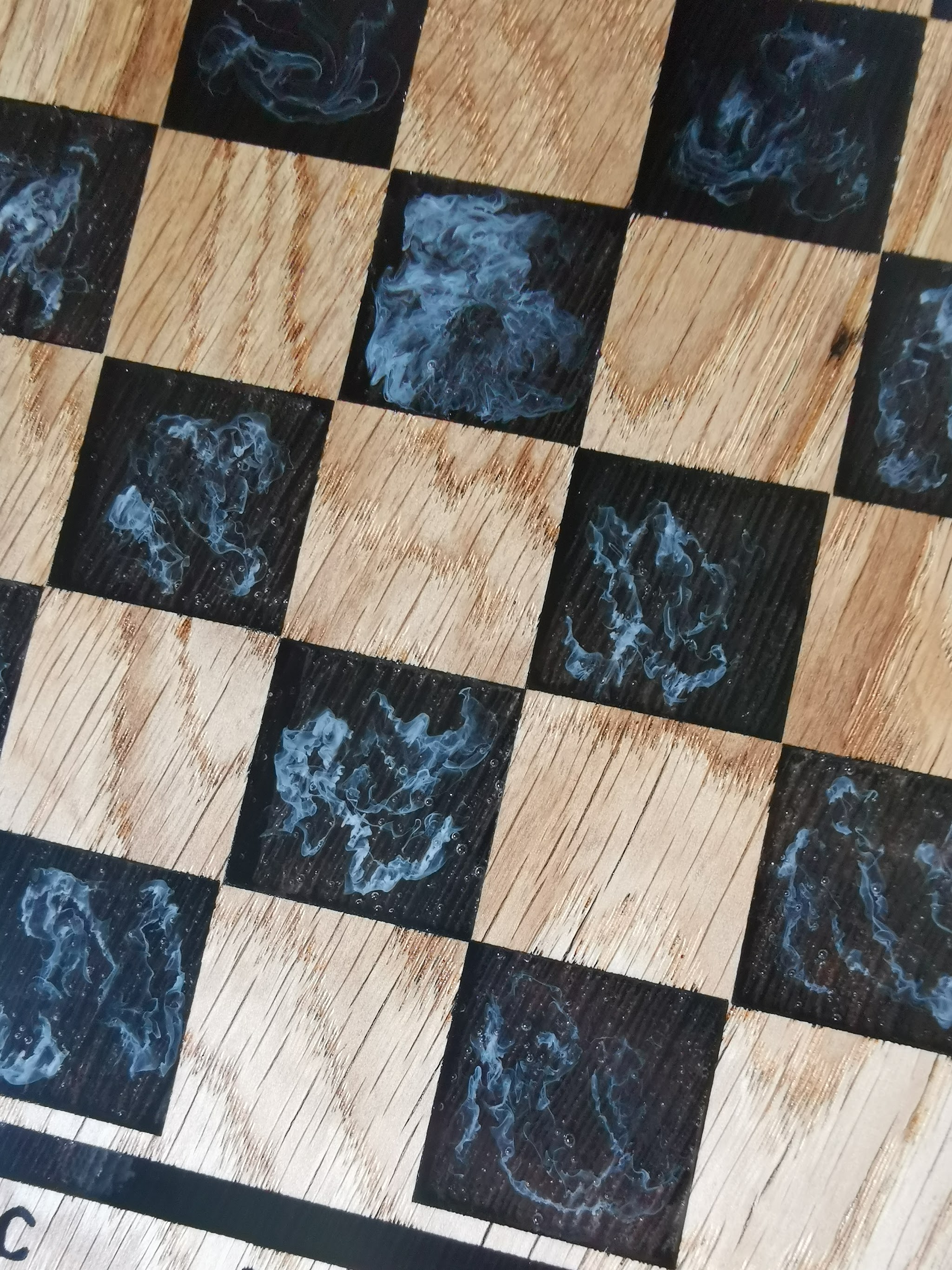 Close-up van epoxy vakjes in eiken schaakbord met witte rooksliertjes als verbrand-hout effect