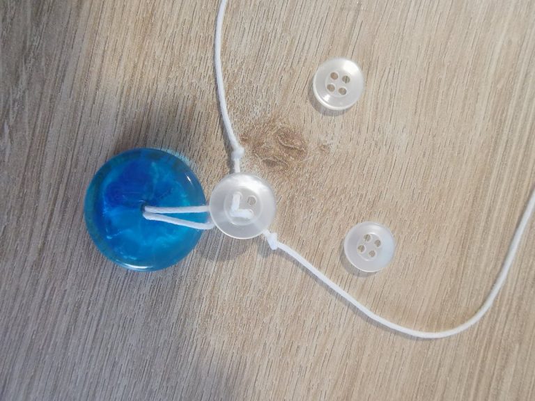 Twee kleine knoopjes liggen klaar om vastgeregen te worden richting de hals