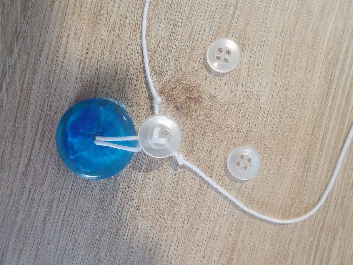 Twee kleine knoopjes liggen klaar om vastgeregen te worden richting de hals