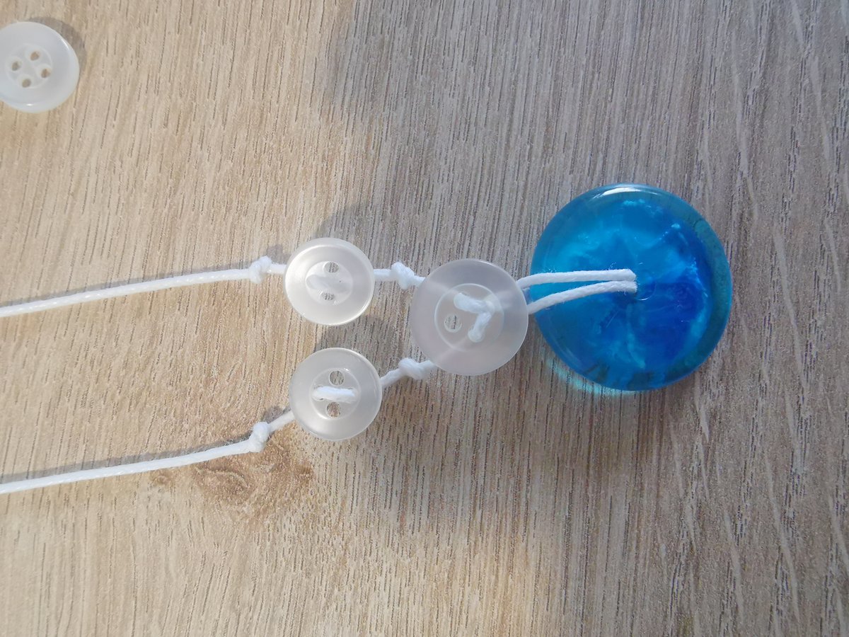 De twee kleine knoopjes zijn vastgeregen en vastgezet richting de hals