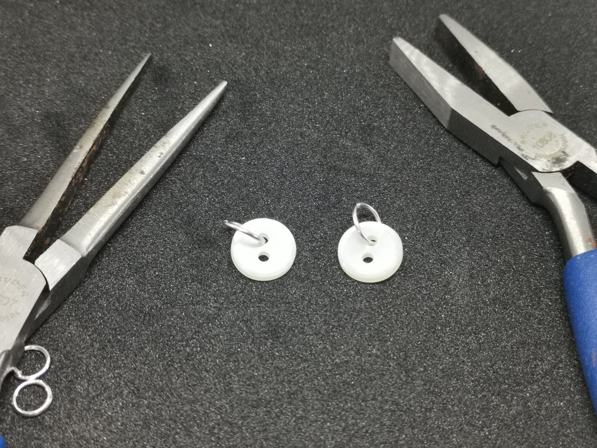 Grote jumping rings door de knopen bevestigd met twee tangetjes