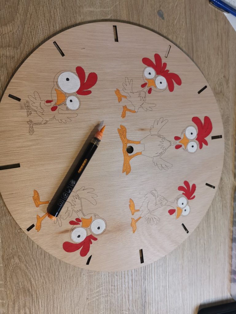 Kippenklok in wording: drie kippen al ingekleurd met rode kam en oranje snavel, twee nog in kaal hout