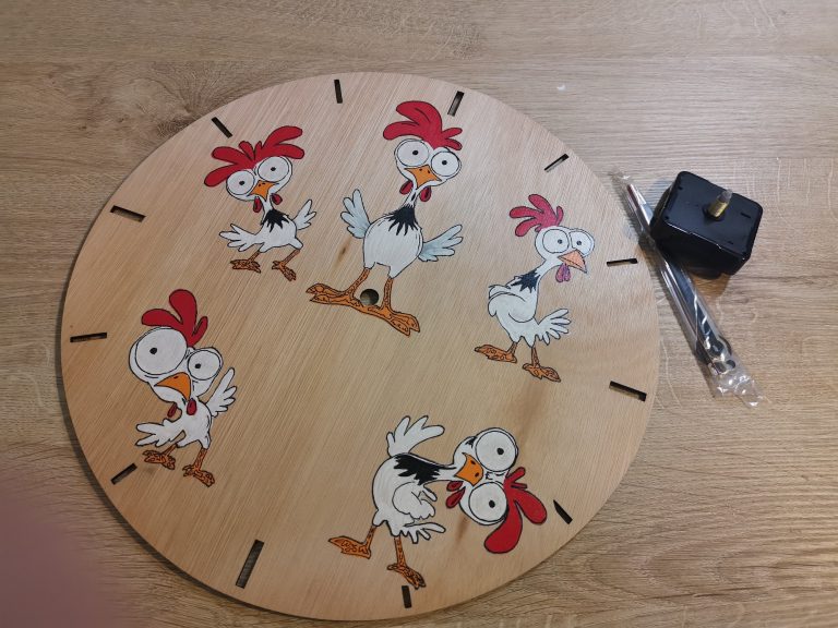 Bijna afgewerkte kippenklok met alle vijf kippen ingekleurd, klaar om het uurwerk en de wijzers te monteren