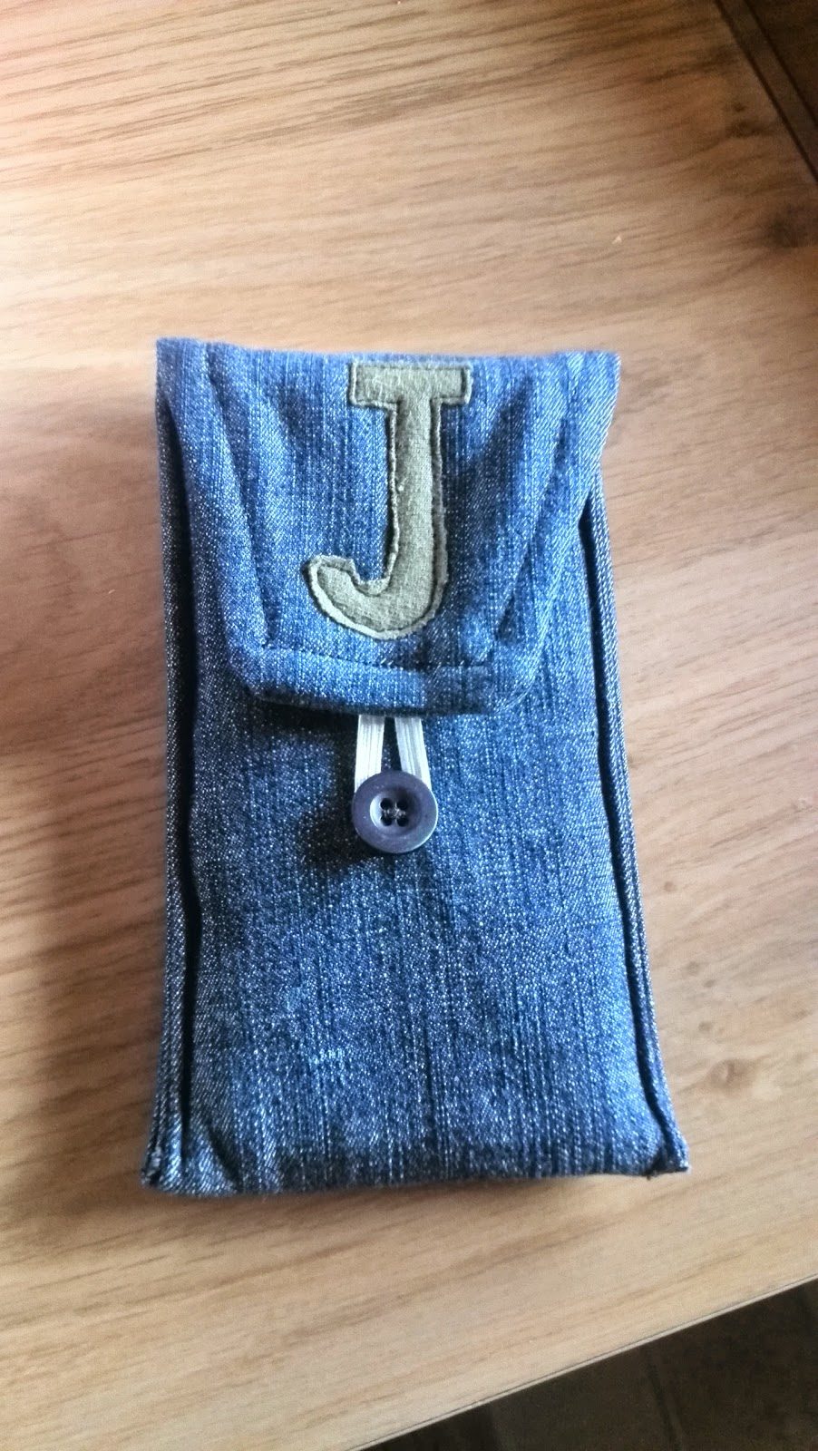 Zelfgemaakt GSM-hoesje van spijkerstof met opgenaaide letter J en drukknoop
