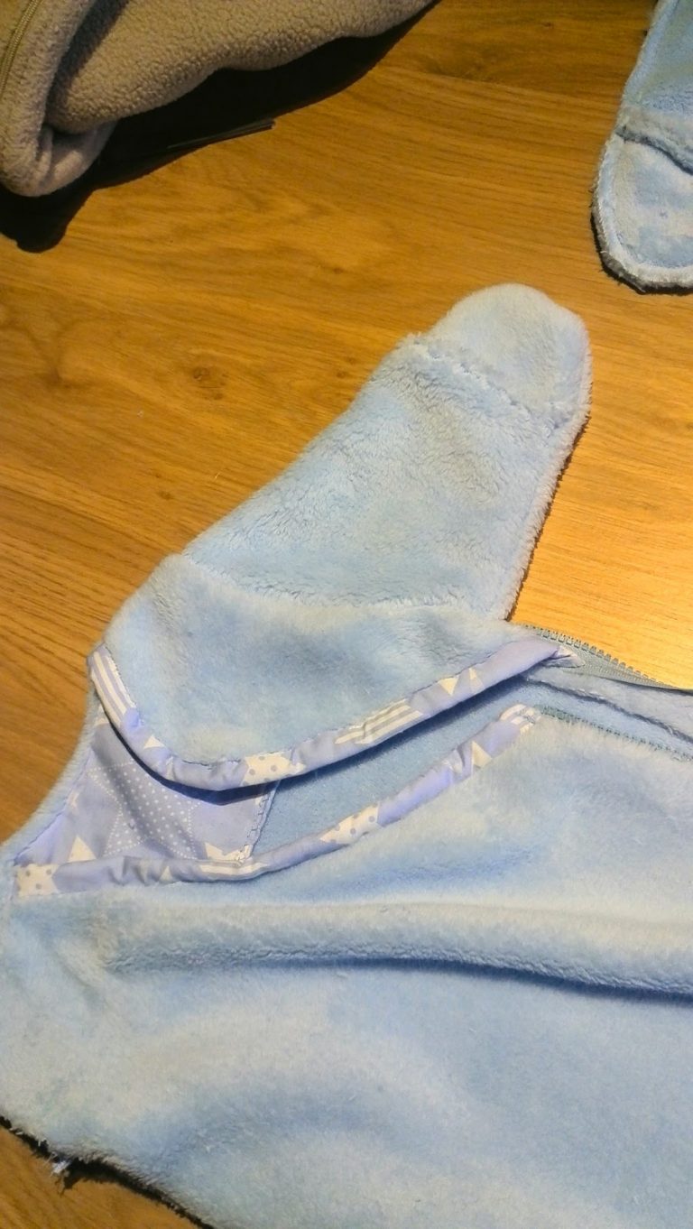 Detail van ingezette mouw met wantje en biaislint afwerking op het babyslaapzakje