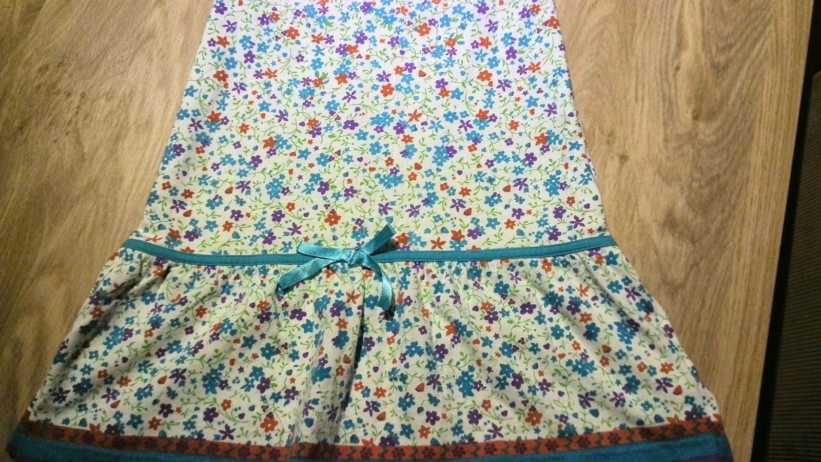 Onderste deel van het kleurrijke kinderjurkje met rok en turquoise strikje