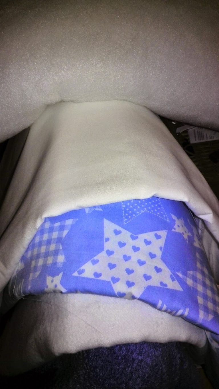 Blauwe stof met sterren- en hartjespatroon en witte fleece voor de wiegbekleding