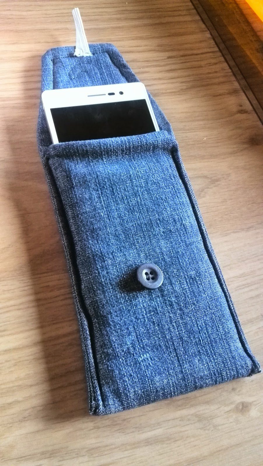 Jeans GSM-hoesje open met smartphone erin en drukknoop als sluiting