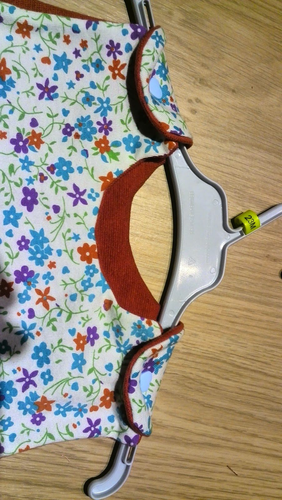 Close-up van de ronde rugopening van het kinderjurkje met biaislint afwerking