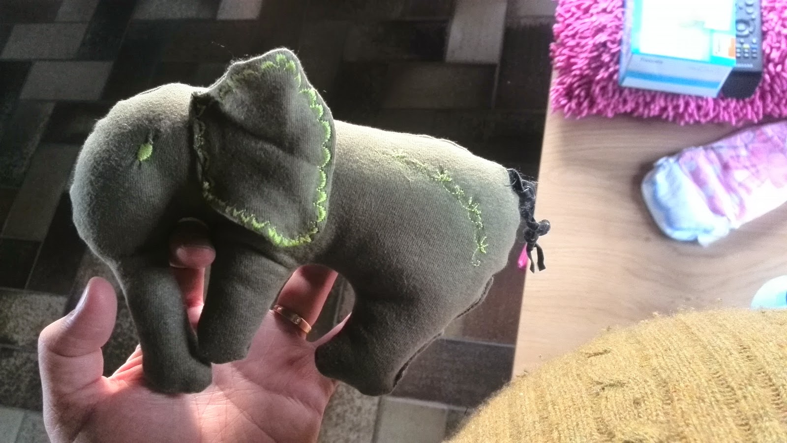 Zelfgemaakt groen olifantje van gerecycleerd T-shirt in de hand