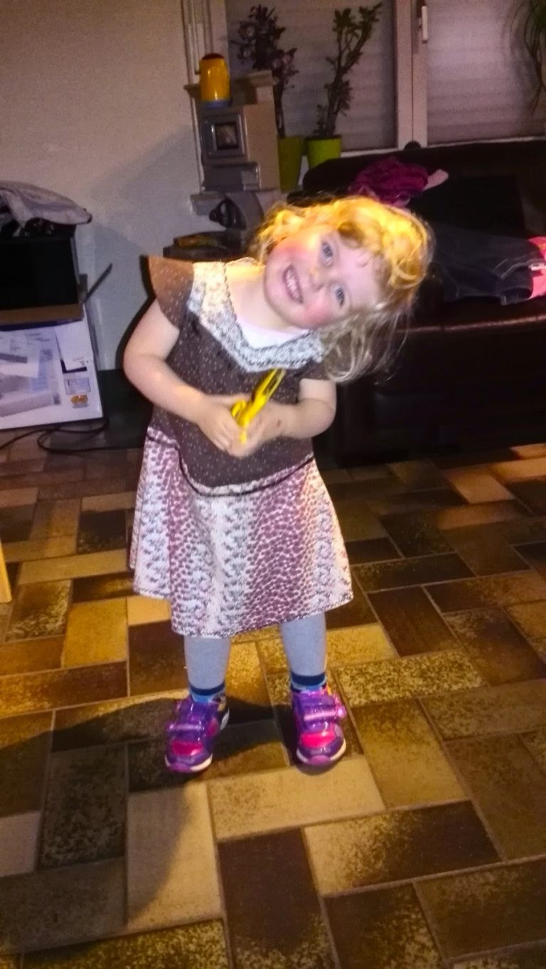 Blond meisje van 3 jaar in een zelfgemaakt jurkje van gerecycleerde kleren