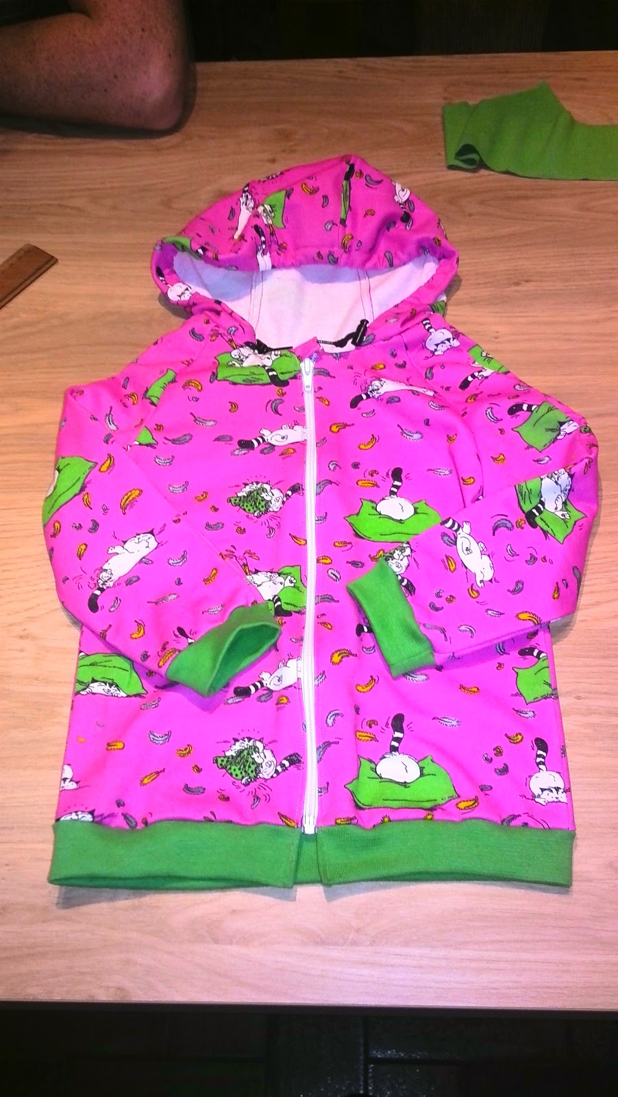 Sweat rose entièrement terminé avec fermeture posée et bord-côte vert, à plat