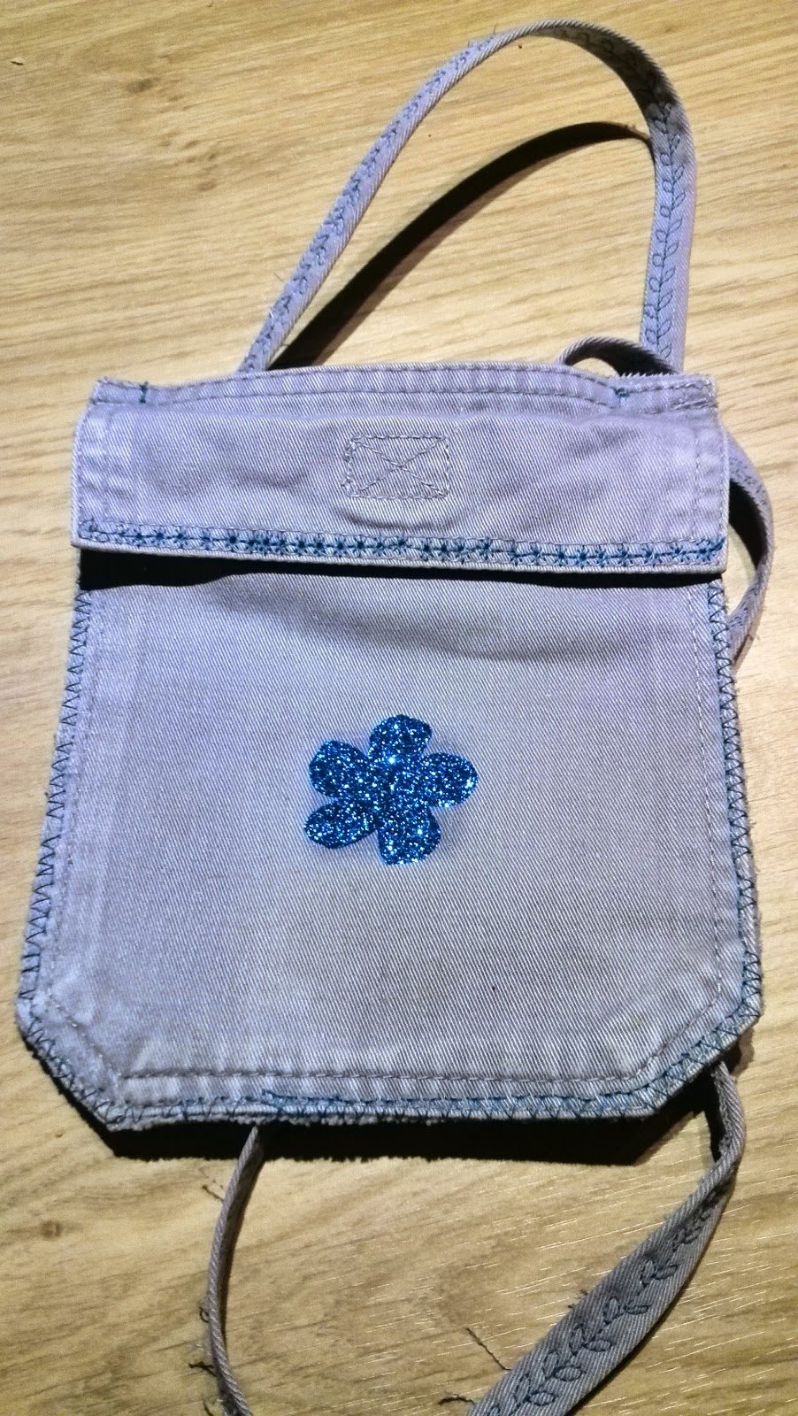 Klein handtasje voor peuter gemaakt van jeanszak met blauwe glitterflex bloem